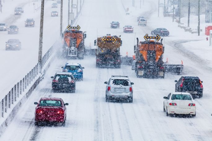 Vehicles driving on a snowy highway 