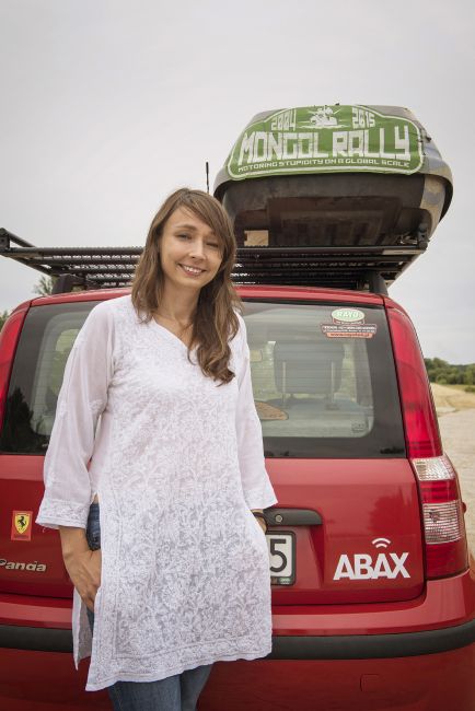 Karolina Jonderko pozuje na tle czerwonego samochodu z logo ABAX 