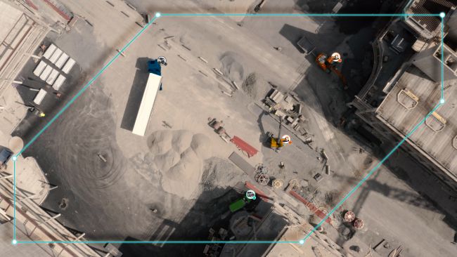 Bird's eye view of construction site with blue geofence around machines